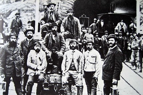 Ouvriers vers 1880 devant le portail sud du tunnel du Gothard à Airolo. Source: https://de.wikipedia.org/wiki/Gotthardtunnel Ouvriers vers 1880 devant le portail sud du tunnel du Gothard à Airolo. Source: https://de.wikipedia.org/wiki/Gotthardtunnel